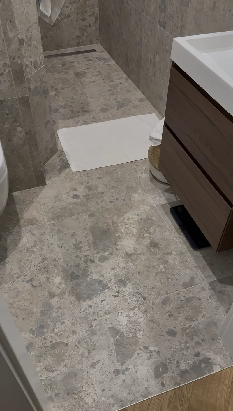 Bad mit Terrazzo-Großformatfliesen und bodengleicher Dusche